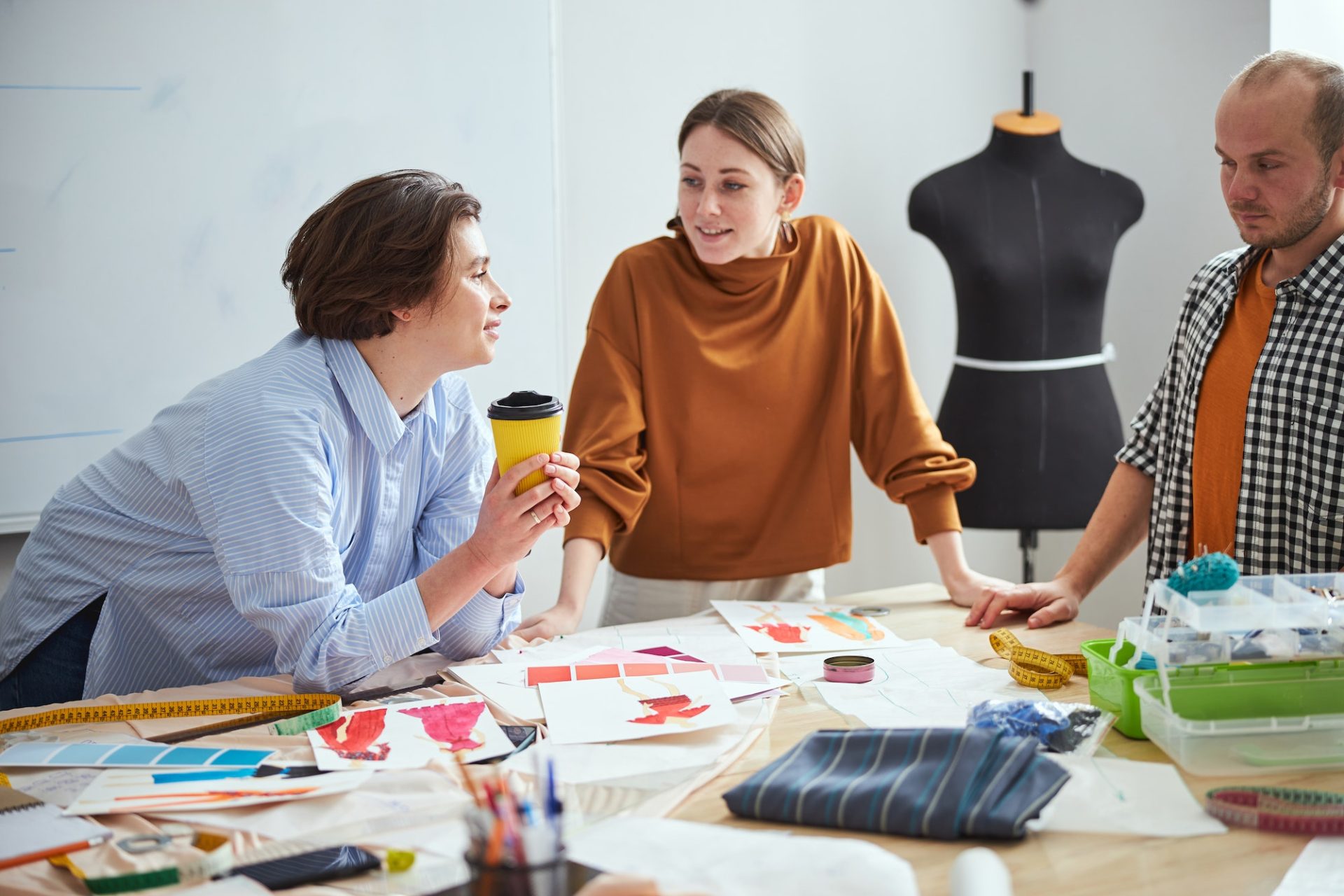 Messy workplace of three creative fashion designers